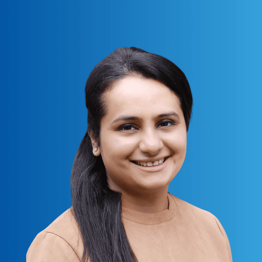 A woman smiling at the camera on a blue background